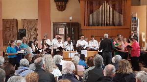 Der gemischte Chor des MGV singverein Freiheit beim Sommerkonzert 2024. Im Vordergrund Zuschauer, im Hintergrund die Orgel der evangelischen Stadtkirche.